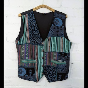 Pode incluir: Um colete de patchwork multicolorido com forro preto e fecho de botões. O colete apresenta uma variedade de padrões, incluindo riscas, paisley e designs geométricos. O colete é feito de um tecido macio e tecido.