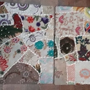 Può includere: Due cuscini quadrati in patchwork con uno sfondo beige e ritagli di tessuto colorati cuciti insieme in un motivo casuale. I cuscini hanno un bordo bianco e sono decorati con piccole perline.