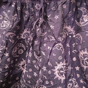 May include: Purple cotton pants with a white print of moons, stars, and suns.