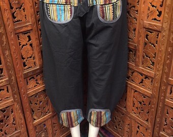 May include: Black pants with a colorful striped waistband and cuffs. The waistband and cuffs have a gray trim. The pants have two pockets on the front.