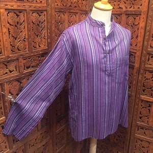 May include: A long-sleeved shirt with a purple and white striped pattern. The shirt has a mandarin collar and a single button closure at the neck.