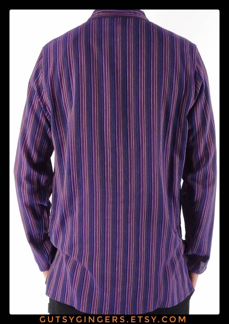 May include: A long-sleeved button-down shirt with a vertical striped pattern in shades of purple, blue, and white.