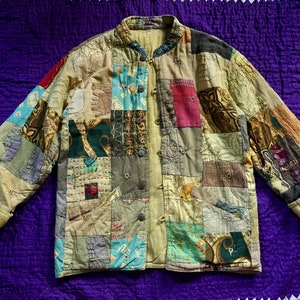 Puede incluir: Una chaqueta de patchwork hecha de varias telas en tonos de marrón, verde, azul y rojo. La chaqueta tiene un cierre de botones en la parte delantera y mangas largas.