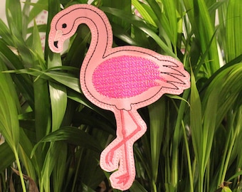 May include: Pink flamingo shaped garden stake with a sparkly finish. The flamingo is standing on one leg with its neck curved.