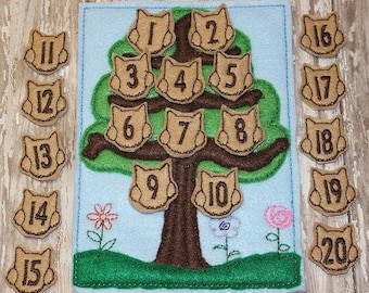 May include: A felt educational toy featuring a tree with numbered owl-shaped cutouts. Additional owl-shaped cutouts with numbers 11-20 are placed around the tree. The tree is on a blue background with green grass and flowers.