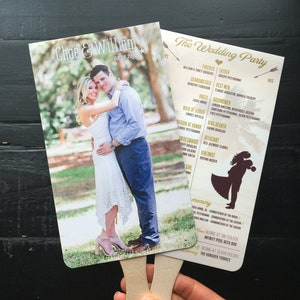 May include: A wedding fan with a photo of the couple on the front and a list of the wedding party on the back. The fan is made of paper and has a wooden handle. The text on the fan reads "Chae & William 08.28.2016" and "The Wedding Party".