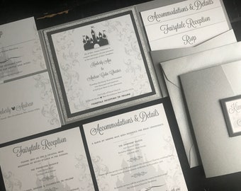May include: A silver and black wedding invitation suite with a fairytale theme. The invitation features a silhouette of a castle and the text "Kimberly Ann to Andrew Louis Charles". The reception card features a block of rooms reserved for guests at The Embassy Suites.