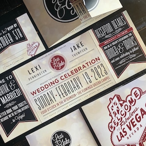 Puede incluir: Conjunto de invitaciones de boda con temática de Las Vegas. La invitación presenta un esquema de color rojo y negro con una fuente vintage. La invitación incluye los nombres de la pareja, la fecha de la boda y la ubicación. La tarjeta RSVP incluye un diseño con temática de Las Vegas con un esquema de color rojo y negro.