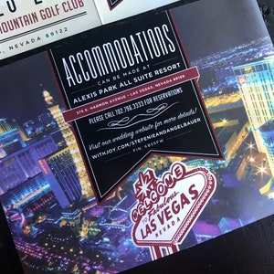May include: A black and white invitation card with red accents. The card features a nighttime aerial view of Las Vegas, Nevada. The text on the card reads "Accommodations can be made at Alexis Park All Suite Resort 375 E. Harmon Avenue Las Vegas, Nevada 89165 Please call 702.796.3333 for reservations Visit our wedding website for more details! Withjoy.com/Stefenieandangelbauer PIN: 6855FW Welcome to Fabulous Las Vegas Nevada".