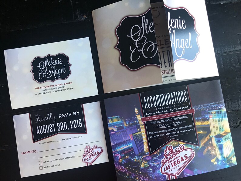 May include: Wedding invitation suite with a black and white design featuring the names "Stefenie & Angel" and a red and white "Welcome to Fabulous Las Vegas" sign. The invitation includes details about the wedding location, date, and RSVP information.
