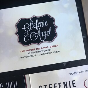 May include: A white card with a black and red border. The text "Stefenie & Angel" is written in cursive script. The text "The Future Mr. & Mrs. Bauer" is written in a smaller font below the names. The address "36 Ridgeway Street, Watsonville, California 95076" is written below the names.