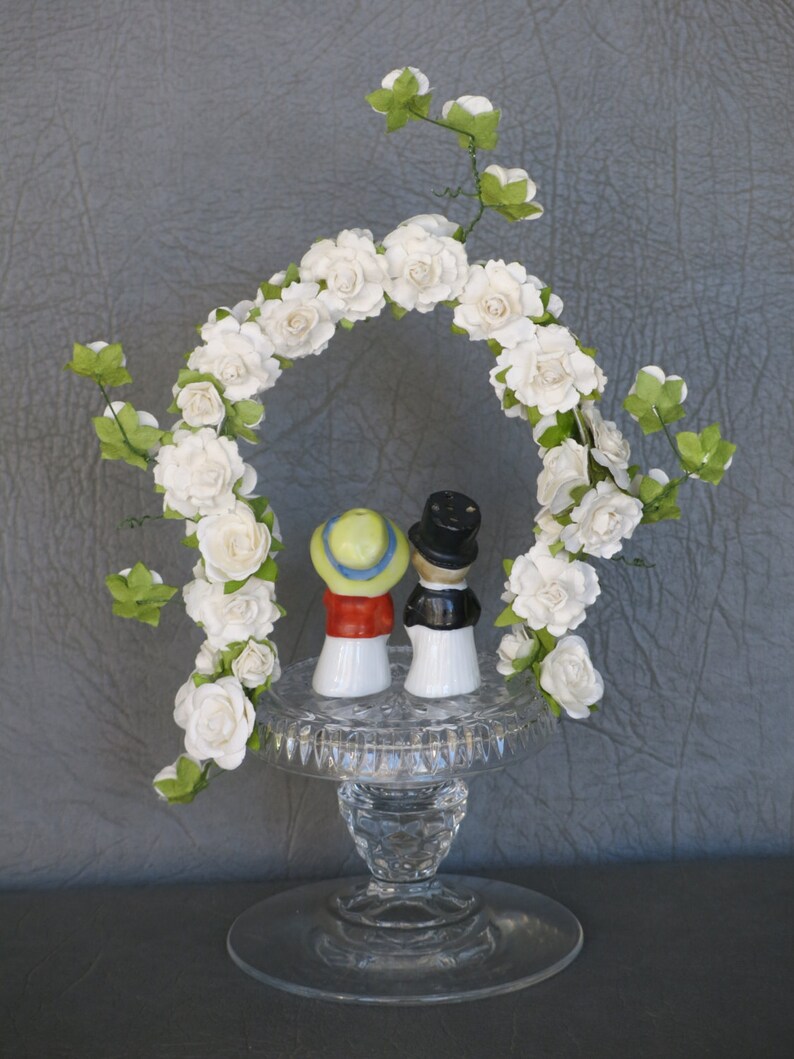 Wedding or Anniversary cake topper. Vintage porcelain bride and groom set atop cut crystal base and arch of white paper flowers. image 4