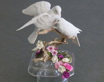 Wedding or Anniversary cake topper.  Fine porcelain doves on a branch affixed to glass crystal base and adorned with paper flowers.