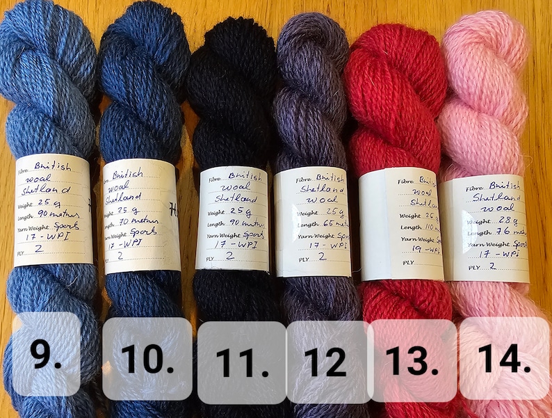 May include: Six skeins of British Shetland wool yarn in various colors: light blue, dark blue, black, purple, red, and pink. Each skein is labeled with weight and length information. Ideal for knitting and crochet projects.