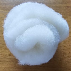 Handbearbetat och kardat vitt Shetland fleece och handspunnet garn.