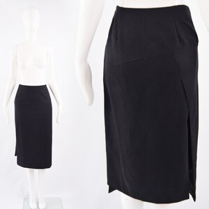 Puede incluir: Una falda negra hasta la rodilla con una abertura lateral. La falda tiene un dise&ntilde;o sencillo y entallado y est&aacute; hecha de una tela lisa y resistente a las arrugas.