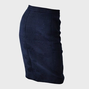 May include: A dark blue skirt with a floral pattern. The skirt is knee-length and has a fitted silhouette.