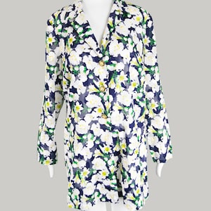 May include: A long-sleeved, white button-up shirt with a floral print in shades of green, white, and blue. The shirt has a V-neck and gold buttons.