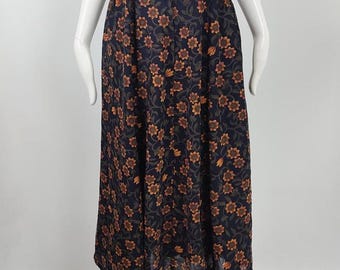 Könnte beinhalten: Ein langer, dunkelblauer Rock mit einem Blumenmuster in Orange- und Brauntönen. Der Rock hat einen Knopfverschluss an der Taille und eine fließende A-Linien-Silhouette. Der Stoff scheint leicht und luftig zu sein.