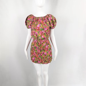 May include: A short, pink and green floral print dress with a gathered neckline and short puff sleeves.
