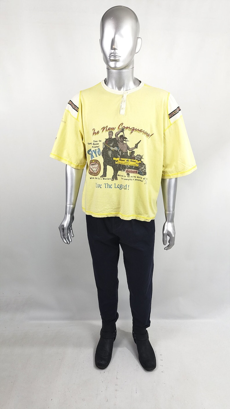 A vintage 80s new wave t shirt in a yellow with a baseball grandad collar and pirate print on the front.