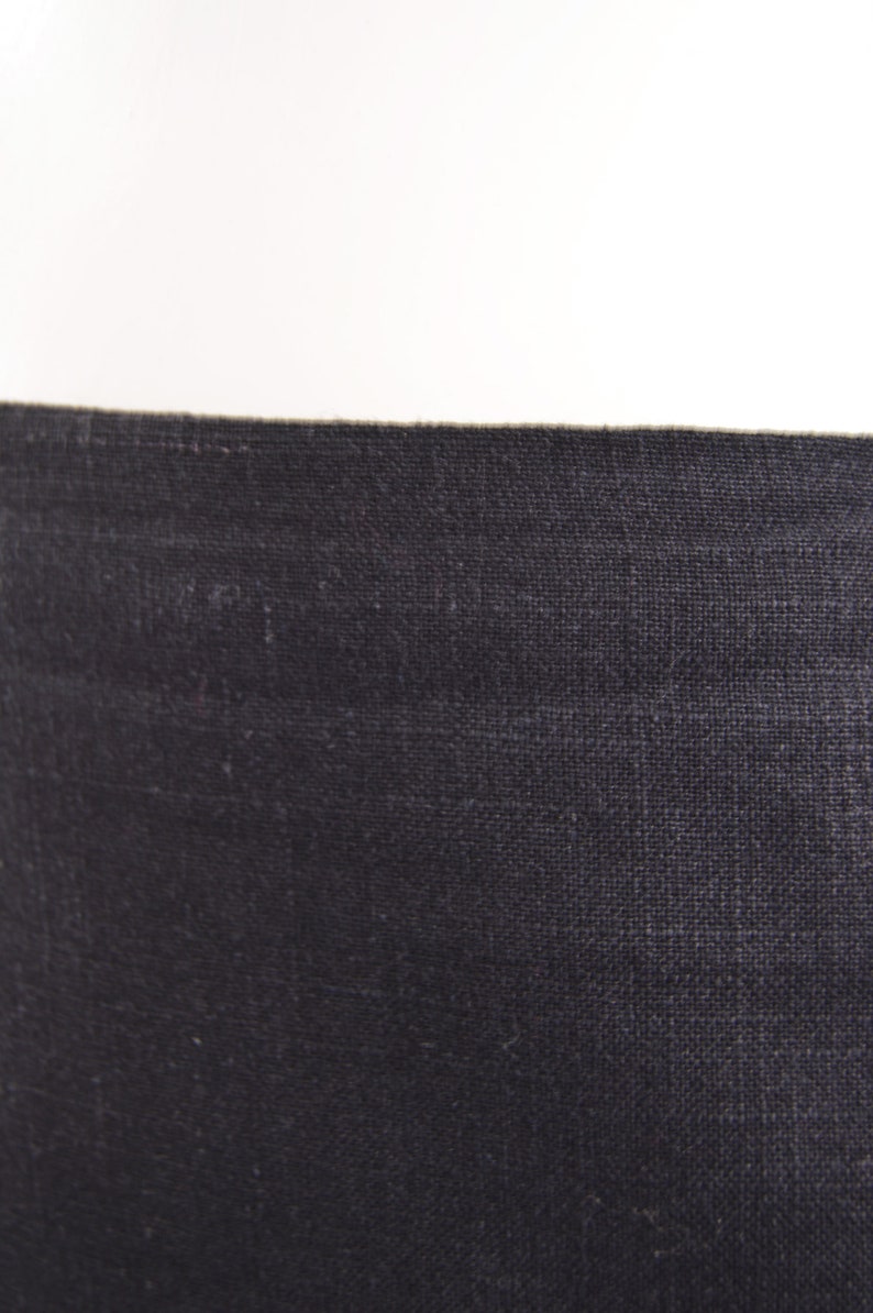 Puede incluir: Primer plano de una tela gris oscura con textura tejida.