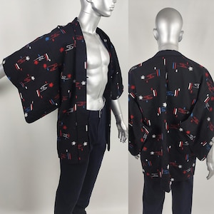 Op de afbeelding: Een zwarte kimono met een geometrisch patroon in rood, wit en blauw. De kimono heeft een traditionele Japanse stijl met wijde mouwen en een losse pasvorm.