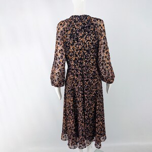May include: A long-sleeved dress with a brown and black animal print pattern. The dress has a round neckline and a flowing skirt.