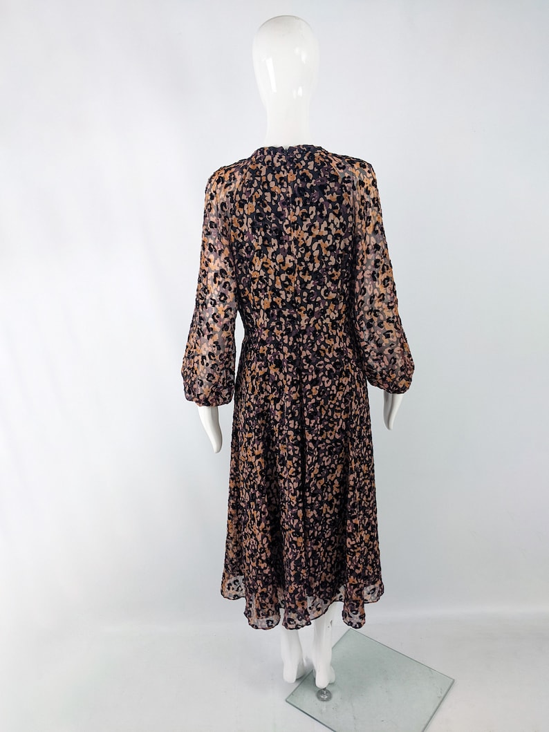 May include: A long-sleeved dress with a brown and black animal print pattern. The dress has a round neckline and a flowing skirt.