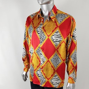 May include: A long-sleeve button-down shirt featuring a vibrant diamond pattern in red, gold, and black and white animal prints. The design includes alternating squares of solid red, ornate gold filigree, black and white leopard spots, and zebra stripes.