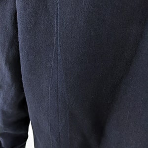 以下が含まれることがあります： 背中に1本の縫い目が入った濃い青色のジャケット