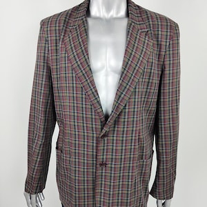 Puede incluir: Una chaqueta de traje de cuadros con cierre de dos botones. La chaqueta es marrón, verde, roja y blanca.