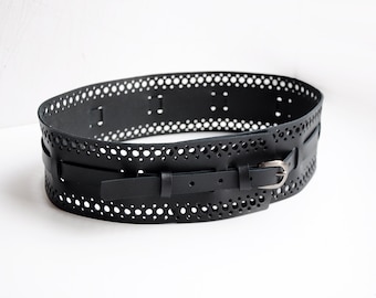 May include: A black leather belt with a cut-out design and a silver buckle.