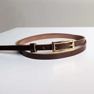 Cintura sottile in vera pelle, marrone, con fibbia dorata.