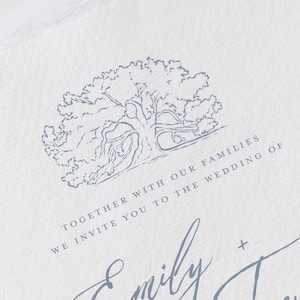 May include: A white invitation with a blue tree illustration and elegant script. The text reads "Together with our families, we invite you to the wedding of Emily + Trevor."