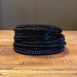 May include: A stack of black leather bracelets with black crystal embellishments.