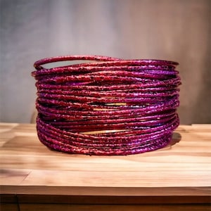 May include: A stack of purple and gold metallic wire hoops, creating a decorative bowl shape.