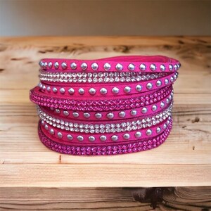May include: A pink leather wrap bracelet with silver studs and clear and pink rhinestones.