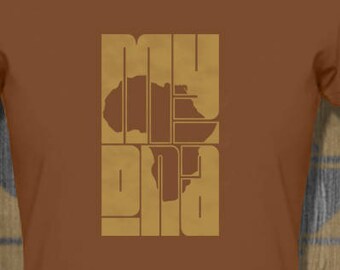 May include: A brown t-shirt with the text "My Africa" printed in a blocky, vintage style font. The text is outlined in a darker brown color and the letter "A" is replaced with an outline of the continent of Africa.