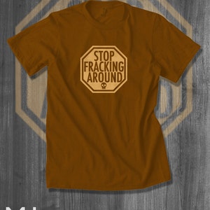 May include: A brown t-shirt with a stop sign graphic that says "Stop Fracking Around".