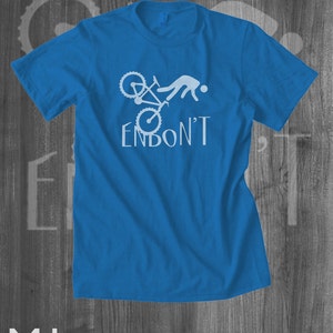 May include: A royal blue t-shirt with a white graphic of a person falling off a bicycle with the text "ENBON'T".