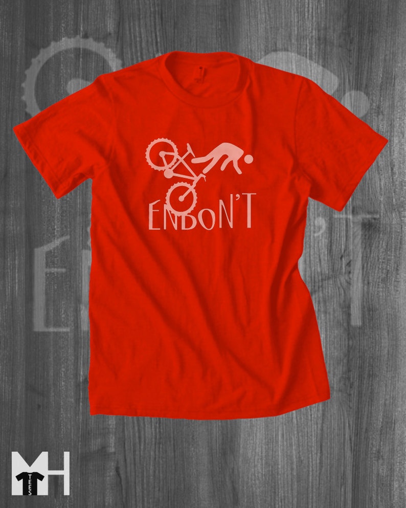 May include: Red t-shirt with a white graphic of a person falling off a bicycle with the text "ENBON'T".