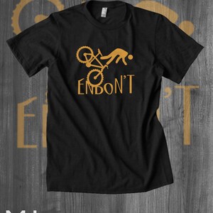 May include: Black t-shirt featuring a graphic of a person falling off a bicycle with the text "Endon't" in gold.