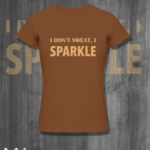 May include: A brown t-shirt with the text "I don't sweat, I sparkle" in a light brown colour.