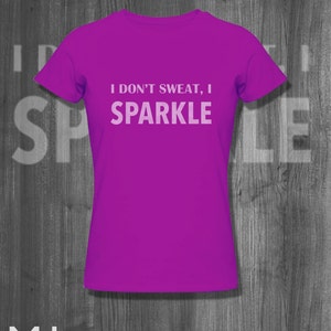 May include: A purple t-shirt with the text "I don't sweat, I sparkle" printed in white.