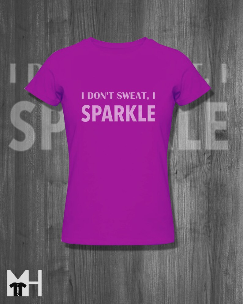 May include: A purple t-shirt with the text "I don't sweat, I sparkle" printed in white.