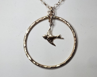 14k Gold circle Pendant embellished with a Gold Swallow.