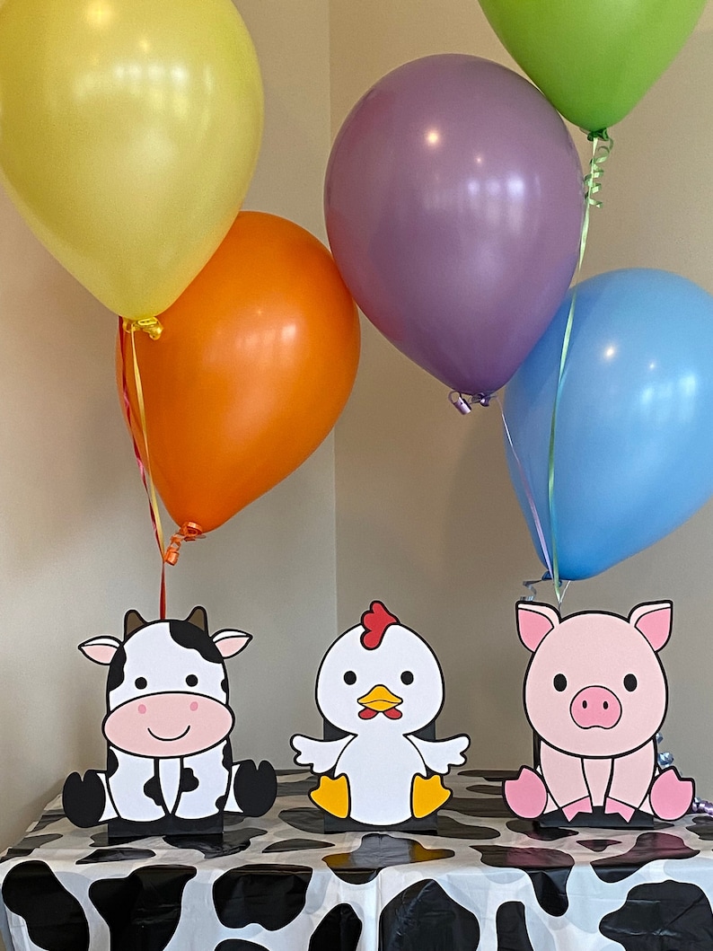 Farm animals cow, chicken and pig party table decorations.  Each centerpiece can stand on their own or add balloons and a balloon weight inside the kraft bag.  Each die cut measures approximately 9" tall.