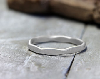 Puede incluir: Un anillo de plata con una banda texturizada y ondulada.