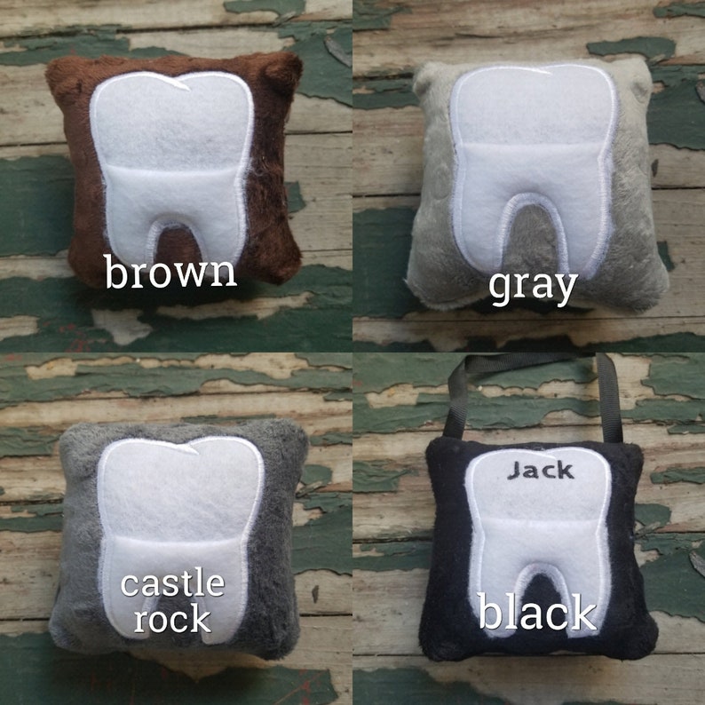 May include: Four plush tooth-shaped pillows in different colours: brown, grey, grey with "castle rock" text, and black with "Jack" text.
